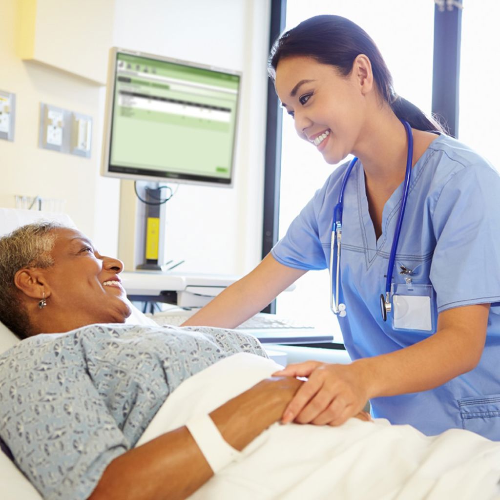 A nurse taking care of a patient at her bedside